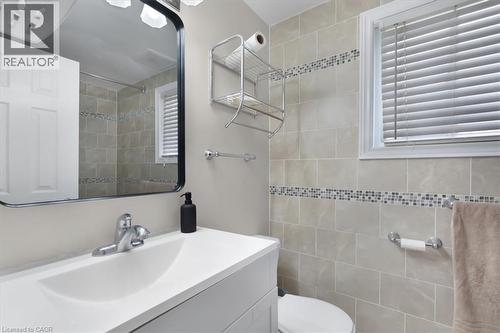 Bathroom featuring a white vanity with integrated sink, chrome faucet, and a large wall mirror - 421 Bairstow Crescent, Waterloo, ON - Indoor Photo Showing Bathroom