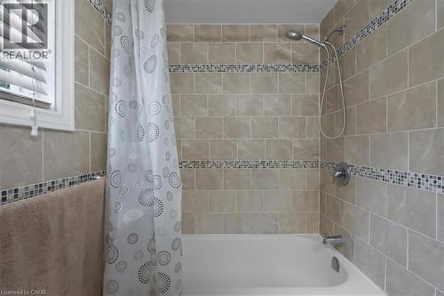 Bathtub with full-height subway tile surround, mosaic accent bands, and chrome fixtures - 421 Bairstow Crescent, Waterloo, ON - Indoor Photo Showing Bathroom
