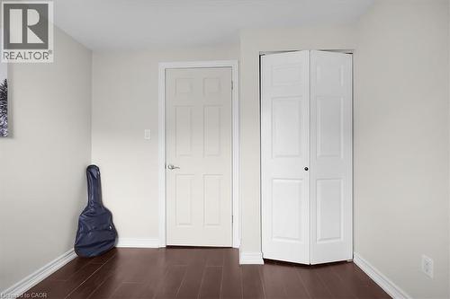 Interior space featuring dark wood-finish flooring, light-colored walls, and white baseboards - 421 Bairstow Crescent, Waterloo, ON - Indoor