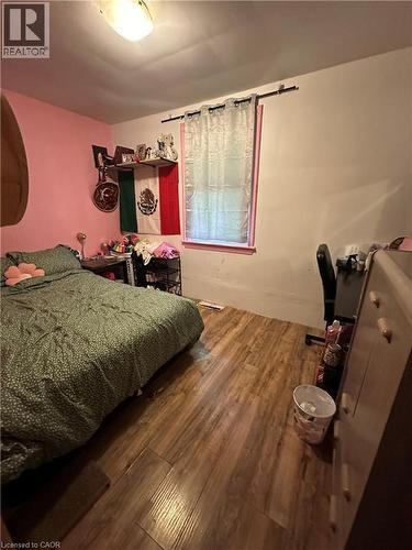 Room featuring wood-finish flooring, a window with a sheer curtain, and a ceiling-mounted light fixture - 240 West 2Nd Street, Hamilton, ON - Indoor
