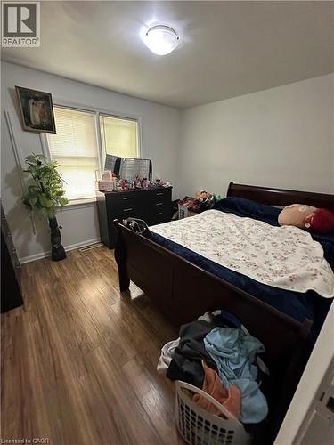 Bedroom featuring wood-finish flooring, white walls, and a ceiling-mounted light fixture - 240 West 2Nd Street, Hamilton, ON - Indoor Photo Showing Bedroom