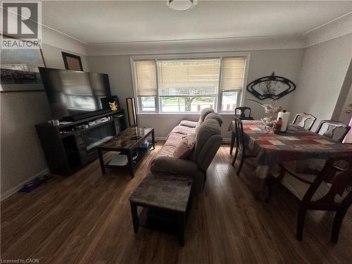 Open concept living and dining area featuring wood-finish flooring, white trim, and a rectangular window with blinds - 240 West 2Nd Street, Hamilton, ON - Indoor Photo Showing Living Room