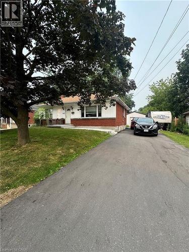Brick and siding exterior featuring a covered front porch and a paved driveway - 240 West 2Nd Street, Hamilton, ON - Outdoor