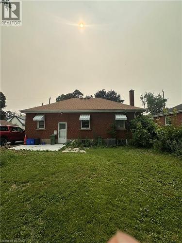 Brick exterior featuring a gabled roof and four window awnings - 240 West 2Nd Street, Hamilton, ON - Outdoor