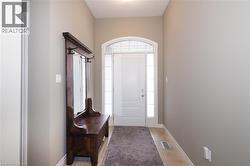 Foyer with glass side lights for natural light featuring an arched transom and sidelight windows, and tile floors - 
