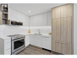 Custom L shaped kitchen with paneled appliances - 