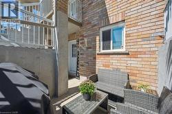 Private patio area featuring brick exterior, white framed window, and concrete privacy wall - 