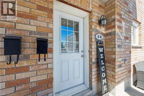 Brick exterior with a white entry door featuring upper louvered glass - 50 Howe Drive Unit# 9D, Kitchener, ON - Outdoor