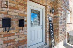 Brick exterior with a white entry door featuring upper louvered glass - 