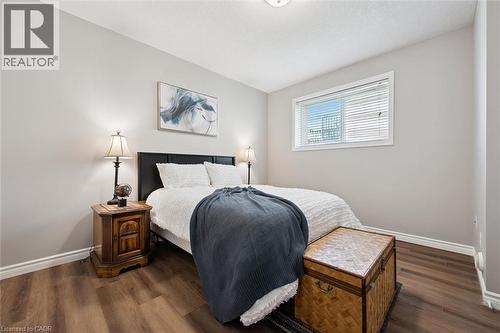 Bedroom featuring wood-finish flooring, a contemporary window with blinds, and light gray wall paint - 50 Howe Drive Unit# 9D, Kitchener, ON - Indoor Photo Showing Bedroom
