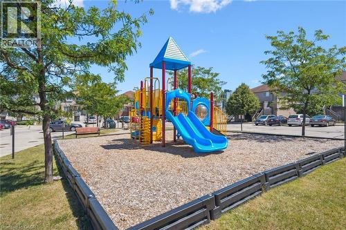 Community playground featuring a multi-level play structure with dual slides and climbing elements - 50 Howe Drive Unit# 9D, Kitchener, ON - Outdoor