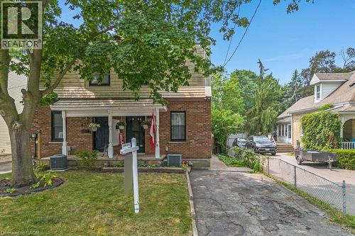 Brick exterior with partial horizontal siding, covered front porch, and a paved driveway - 456 Margaret Street, Cambridge, ON - Outdoor