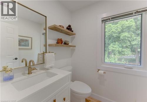 Bathroom featuring a white vanity with an integrated rectangular sink, bronze-finish faucet, and a large gold-framed mirror - 307 Grand River Boulevard, Kitchener, ON - Indoor Photo Showing Bathroom