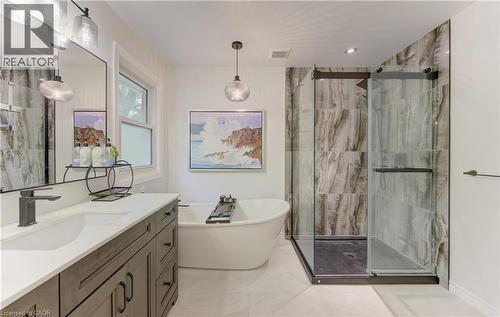 White bathroom featuring a freestanding tub, glass-enclosed shower with stone-look tile, and a double vanity with white countertop - 307 Grand River Boulevard, Kitchener, ON - Indoor Photo Showing Bathroom