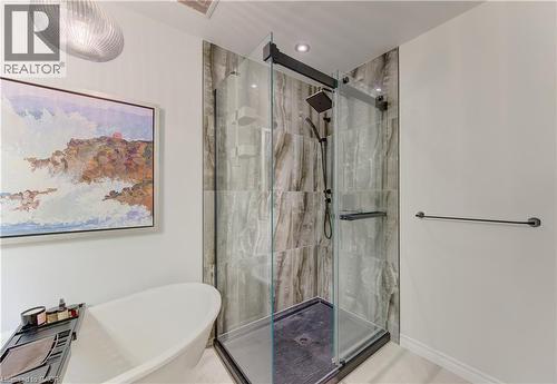 Freestanding soaking tub complemented by a glass-enclosed shower with a matte black fixture - 307 Grand River Boulevard, Kitchener, ON - Indoor Photo Showing Bathroom