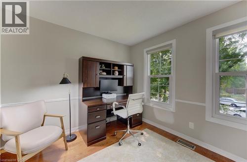 Dedicated room featuring wood-finish flooring, two large windows with roller shades, and light-toned walls with chair rail molding - 307 Grand River Boulevard, Kitchener, ON - Indoor Photo Showing Other Room