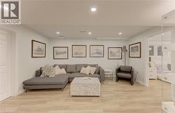 Spacious room featuring light wood-finish flooring, recessed lighting, and white baseboards - 
