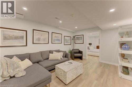 Recessed lighting illuminates an open living area featuring light wood-finish flooring and a white built-in shelving unit - 307 Grand River Boulevard, Kitchener, ON - Indoor Photo Showing Living Room