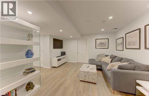 Open-concept living space featuring light wood-finish flooring, recessed ceiling lighting, a built-in media console, and a white paneled door - 307 Grand River Boulevard, Kitchener, ON - Indoor Photo Showing Other Room