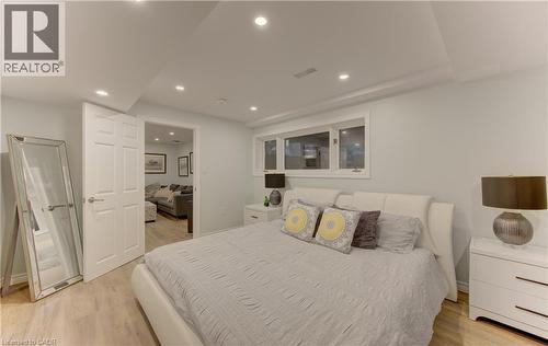Bedroom featuring contemporary wood-finish flooring, recessed lighting, and a white six-panel door - 307 Grand River Boulevard, Kitchener, ON - Indoor Photo Showing Bedroom