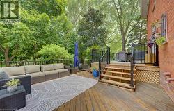 Multi-level wooden deck featuring black metal railings and brick exterior - 