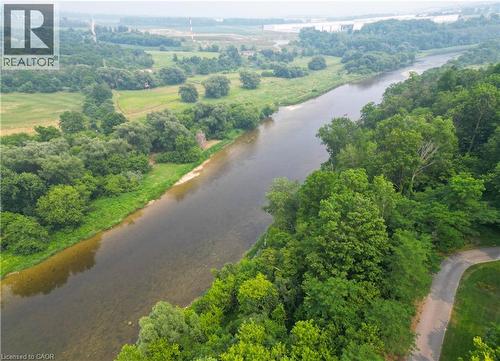 Riverfront property featuring extensive tree coverage, a natural riverbed, and a paved road bordering the perimeter - 307 Grand River Boulevard, Kitchener, ON - Outdoor With Body Of Water With View