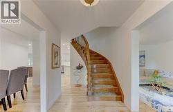Hardwood staircase with decorative balusters and wood-finish flooring - 