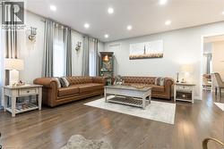 Spacious living area featuring wood-finish flooring, recessed lighting, and light gray wall paint - 
