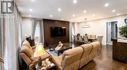 Open-concept living and dining area featuring rich wood-finish flooring - 