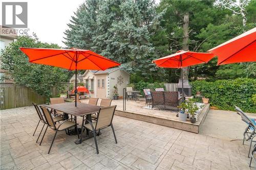 Spacious backyard featuring stamped concrete patio, raised wood deck, privacy fencing, and mature trees - 79 Beaverbrook Crescent, Cambridge, ON - Outdoor With Deck Patio Veranda
