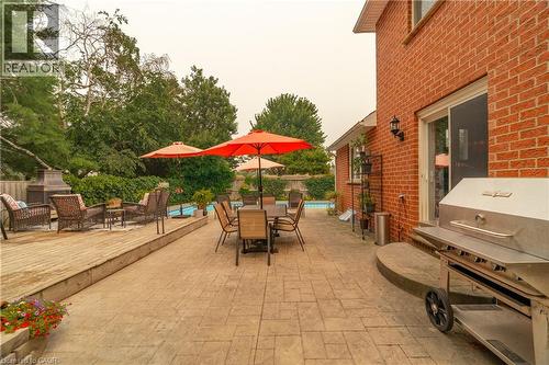 Expansive outdoor living area featuring a stamped concrete patio, a raised wood deck, and a visible swimming pool - 79 Beaverbrook Crescent, Cambridge, ON - Outdoor With Deck Patio Veranda