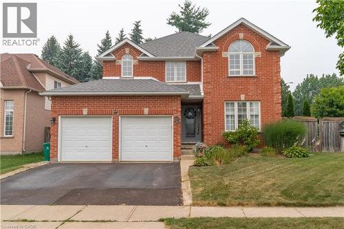 Red brick exterior with a two-car garage, gray front door, and mature landscaping - 79 Beaverbrook Crescent, Cambridge, ON - Outdoor