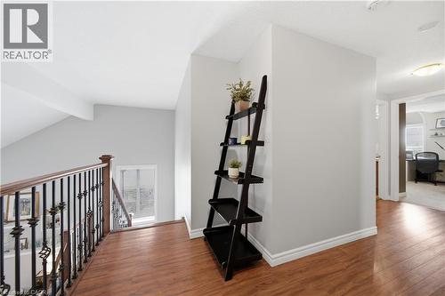 Upper landing featuring wood-finish flooring, a wrought iron and wood balustrade, and a recessed ceiling light - 79 Beaverbrook Crescent, Cambridge, ON - Indoor Photo Showing Other Room