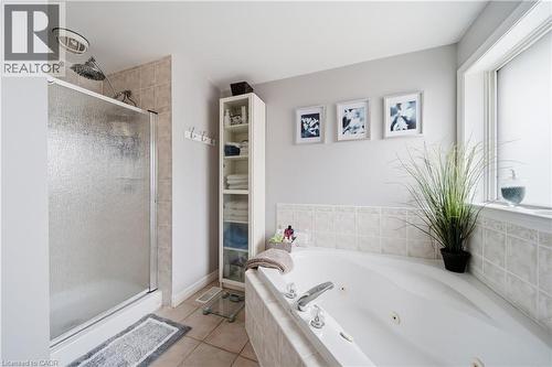 Bathroom with a white jetted tub, ceramic tile surround, and a clear glass shower enclosure - 79 Beaverbrook Crescent, Cambridge, ON - Indoor Photo Showing Bathroom