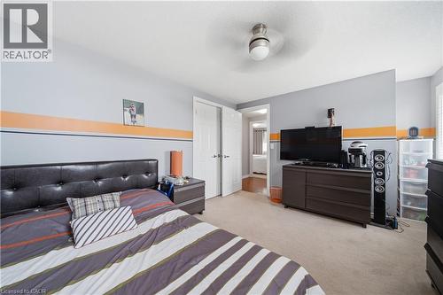 Carpeted room featuring a ceiling fan with light, white trim, and a white interior door - 79 Beaverbrook Crescent, Cambridge, ON - Indoor Photo Showing Bedroom