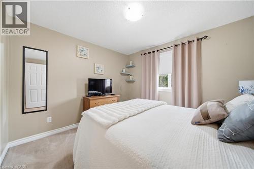 Carpeted room with neutral-toned walls, a window with light-blocking drapes, a flush-mount ceiling light, and white baseboards - 79 Beaverbrook Crescent, Cambridge, ON - Indoor Photo Showing Bedroom