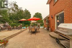 Expansive outdoor living area featuring a stamped concrete patio, a raised wood deck, and a visible swimming pool - 