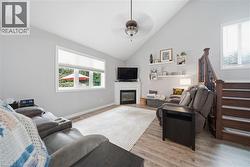 Living area featuring a vaulted ceiling and wood-finish flooring - 