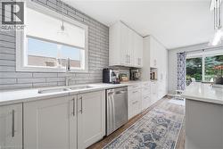 Modern kitchen featuring white shaker cabinetry and stainless-steel appliances - 