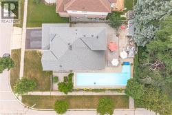 Expansive backyard featuring an in-ground swimming pool, a patio area, and mature perimeter trees - 