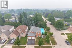 Brick exterior residence featuring an in-ground swimming pool, an attached two-car garage, and a paved driveway - 