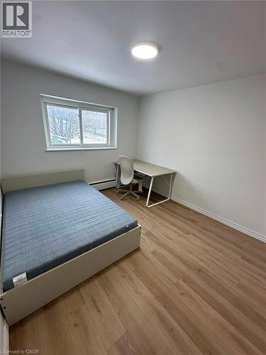 Bright room featuring wood-finish flooring, white walls, and a large window - 145 Macgregor Crescent Unit# 2 (R1), Waterloo, ON - Indoor Photo Showing Bedroom