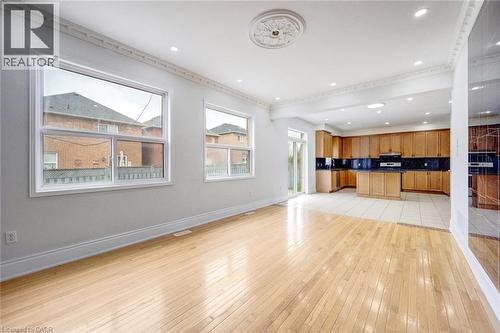 Expansive open-concept living space featuring wood-finish flooring, recessed lighting, and decorative crown molding - 5 Freshspring Drive, Brampton, ON - Indoor