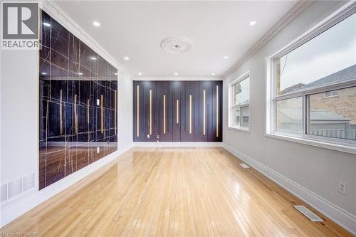 Hardwood flooring complements a decorative wall panel featuring vertical accents - 5 Freshspring Drive, Brampton, ON - Indoor Photo Showing Other Room