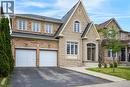 Exterior featuring a stone and brick facade, an arched entryway, multiple gabled rooflines, a two-car garage, and a paved driveway - 5 Freshspring Drive, Brampton, ON  - Outdoor With Facade 