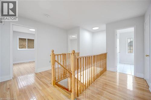 Hardwood flooring throughout the upper hallway with a natural wood staircase railing and balusters - 5 Freshspring Drive, Brampton, ON - Indoor Photo Showing Other Room