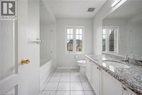 Bathroom featuring a white vanity with a light-toned patterned countertop, an undermount sink, and chrome fixtures - 5 Freshspring Drive, Brampton, ON - Indoor Photo Showing Bathroom