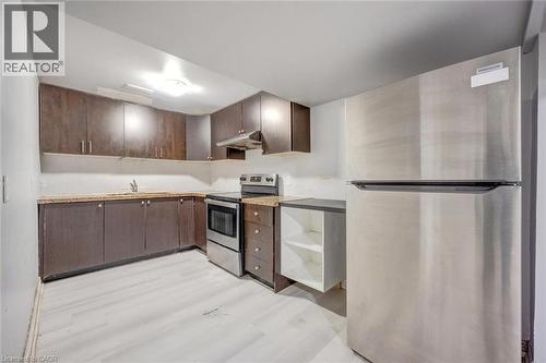 Compact kitchen featuring wood-finish cabinetry, light-toned countertops, and light wood-finish flooring - 5 Freshspring Drive, Brampton, ON - Indoor Photo Showing Kitchen