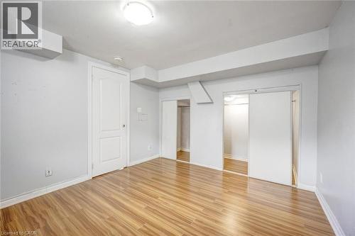 Spacious room featuring wood-finish flooring, white painted walls, and ceiling-mounted lighting - 5 Freshspring Drive, Brampton, ON - Indoor Photo Showing Other Room