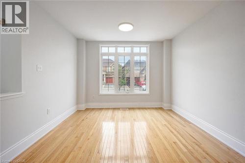 Bright interior space featuring light wood-finish flooring, white baseboards, and a prominent multi-pane window - 5 Freshspring Drive, Brampton, ON - Indoor Photo Showing Other Room